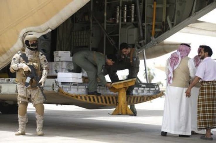 جندي سعودي يحرس عملية إنزال المساعدات من طائرة حربية سعودية في مطار عدن يوم 24 يوليو تموز 2015. تصوير: فيصل الناصر - رويترز.